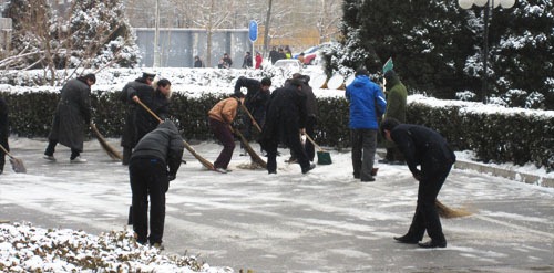Clearing snow in Beijing with shovels and brooms