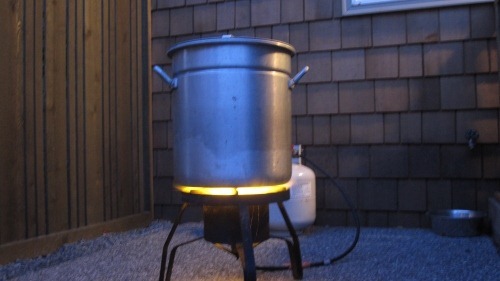 A huge pot on a massive, lit propane burner -- outdoors, of course!