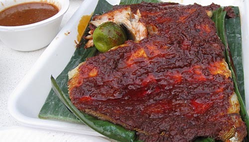Grilled skate wing covered in deep red sambal sauce.
