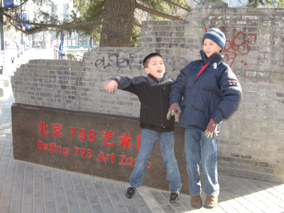 Andrew and Michael jumping in front of 798 Art Zone sign