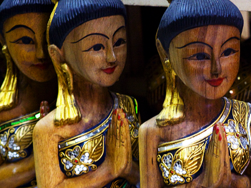 Wooden statues of a Thai women "wai-ing"