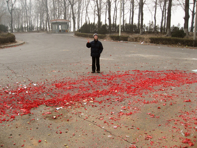 Andrew standing on a swath of red firecracker paper.