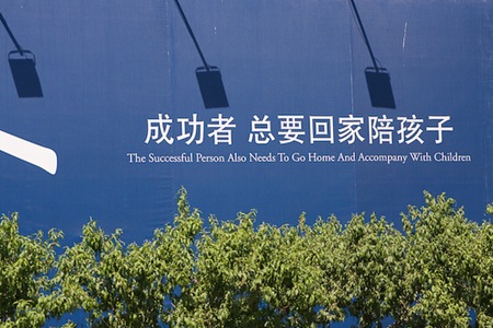 Sign saying "The Successful Person Also Needs To Go Home And Accompany With Children"