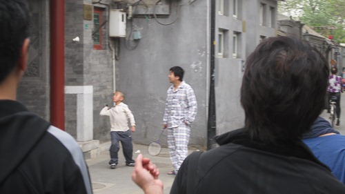 Man playing badminton in his pajamas.