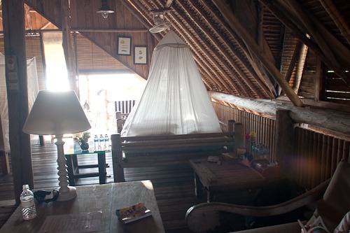 Shot of the inside of the bungalow. Big mosquito netting tent over the bed.